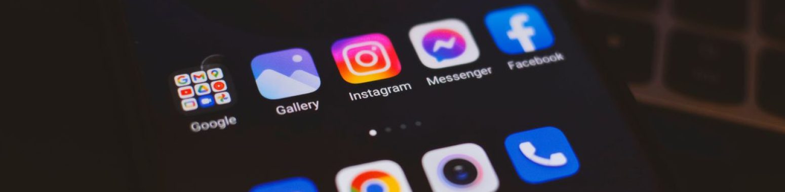 A smartphone displaying popular social media apps in a dimly lit environment, perfect for tech and communication themes.